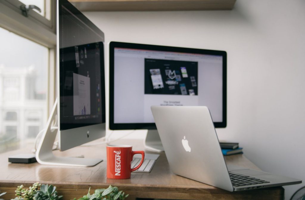 The Art of Drawing Readers In: Your attractive post title goes here A bright modern office setup with computers and a mug on a desk.